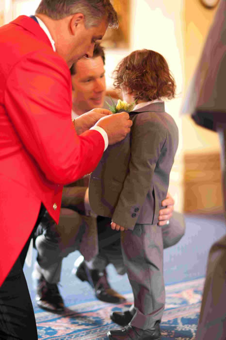 Essex Wedding Toastmaster putting a button hole on a page boy at Down Hall