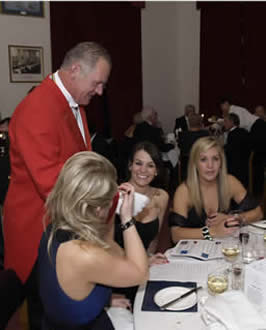 Toastmaster Jude Garland with his three able assistants discussing the charity auction and the modus operandi