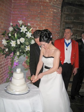 Essex Toastmaster Mark Greatbatch with bride and bridegroom cutting the wedding cake