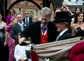 Essex toastmaster Richard Palmer pouring champagne for the bride and bridegroom outside Great Baddow Church, Essex